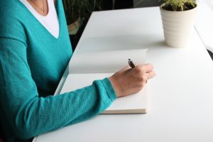 woman writing in personalised notebook